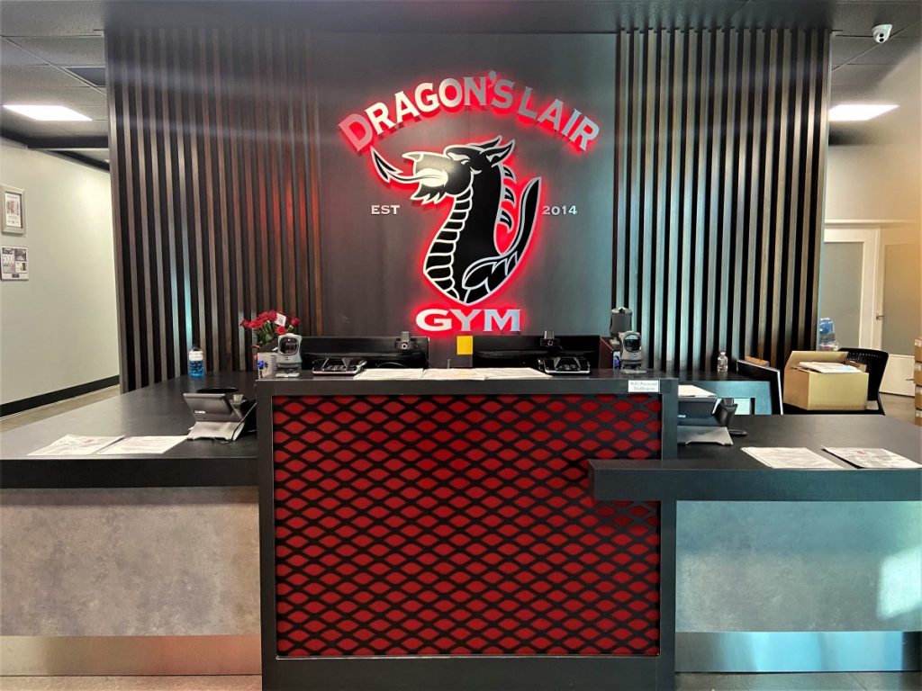 IMG 0228 Today we’re taking you to the Dragon’s Lair gym in Las Vegas, NV.  Here you will find high end fitness center cabinets; as well as an interior brand logo.  The cabinets we designed, built and installed include the reception desk with towel drop, pro shop with retail displays, a fuel zone area and three-tier lockers with cubbies.
